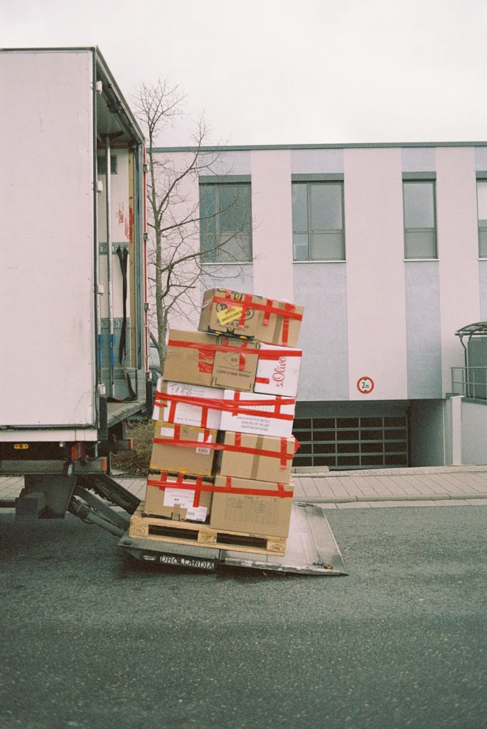 Moving dolly filled with messy boxes being loaded into truck