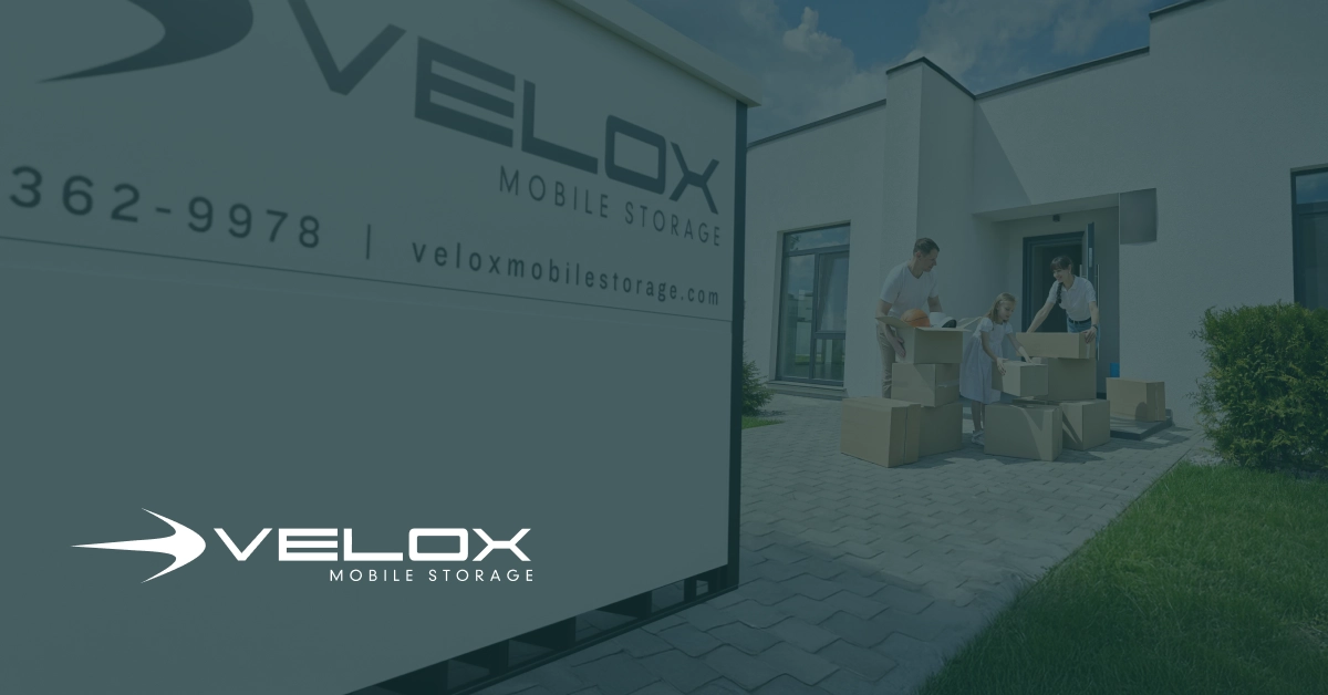 A heavy-duty, weather-sealed Velox portable storage unit sitting on a elevated concrete driveway, packed with organized moving boxes and wrapped furniture to prevent moisture and mold.