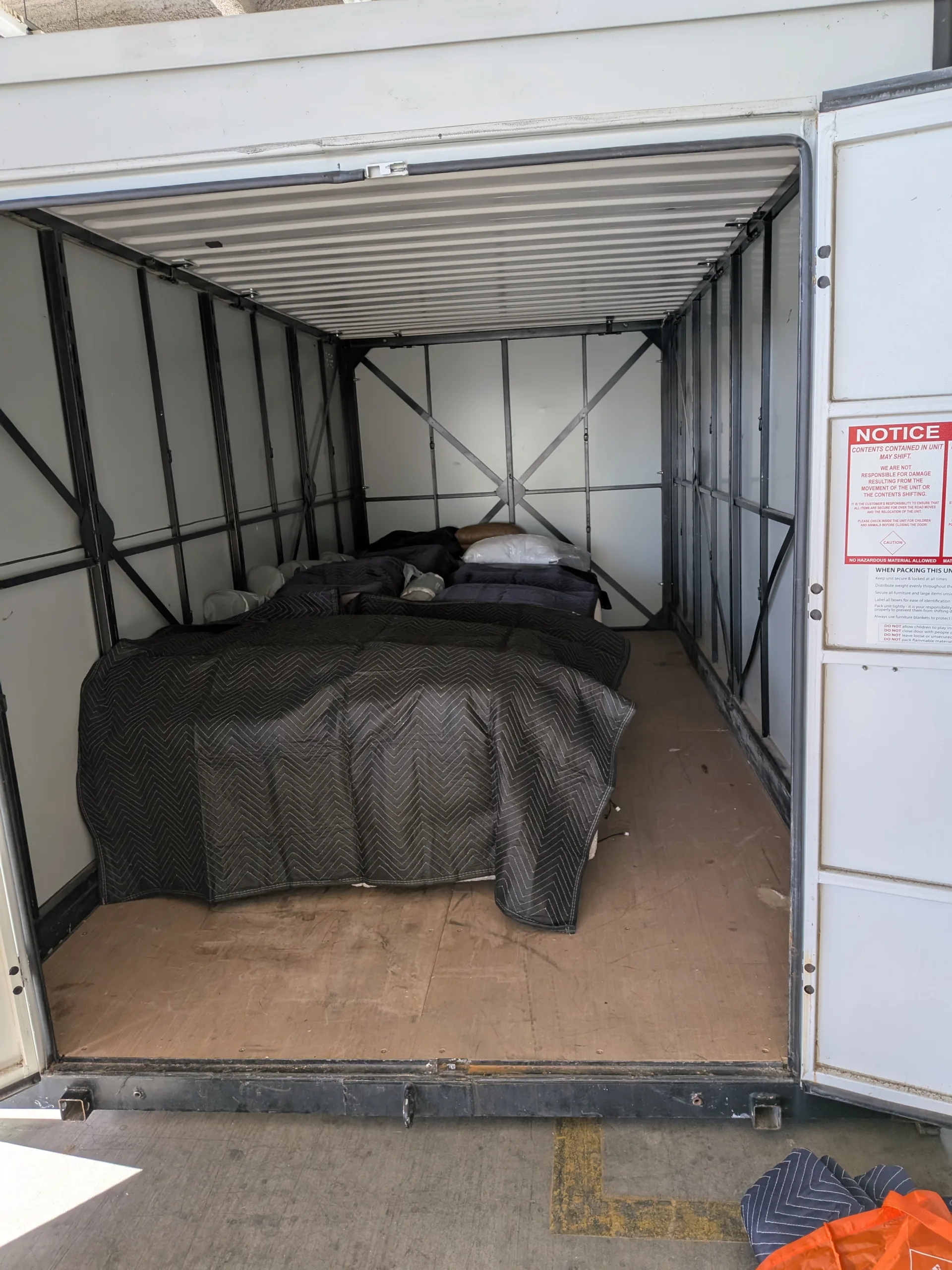 Inside a Velox container: furniture wrapped in moving blankets on a clean, dry floor