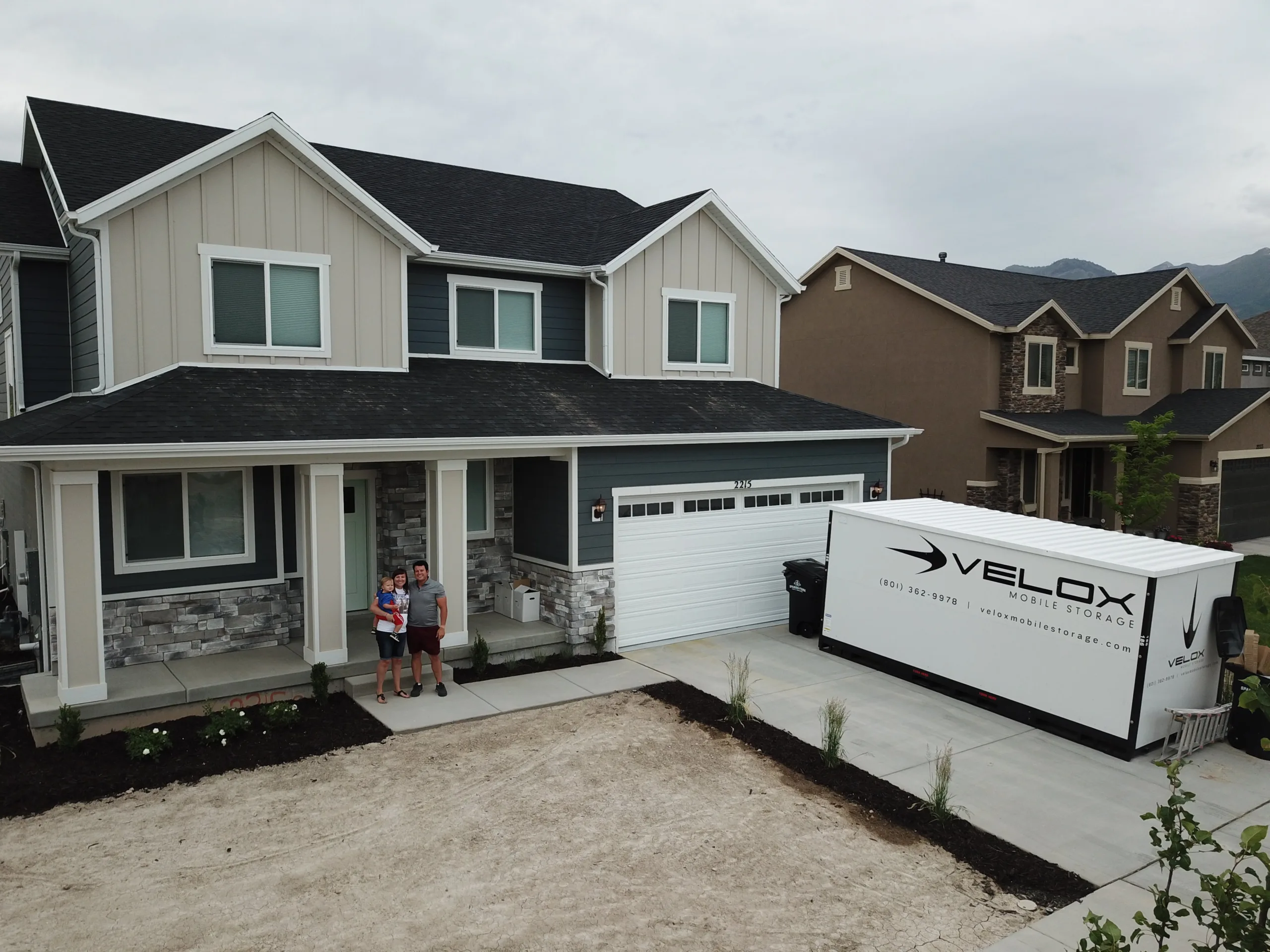A Velox Mobile Storage container in the driveway of a new home while the family moves in