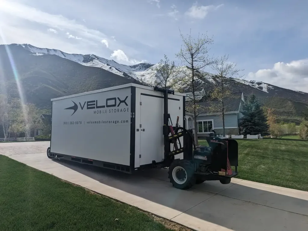 Velox Mule carrying a portable storage container up a long driveway in Mapleton, Utah